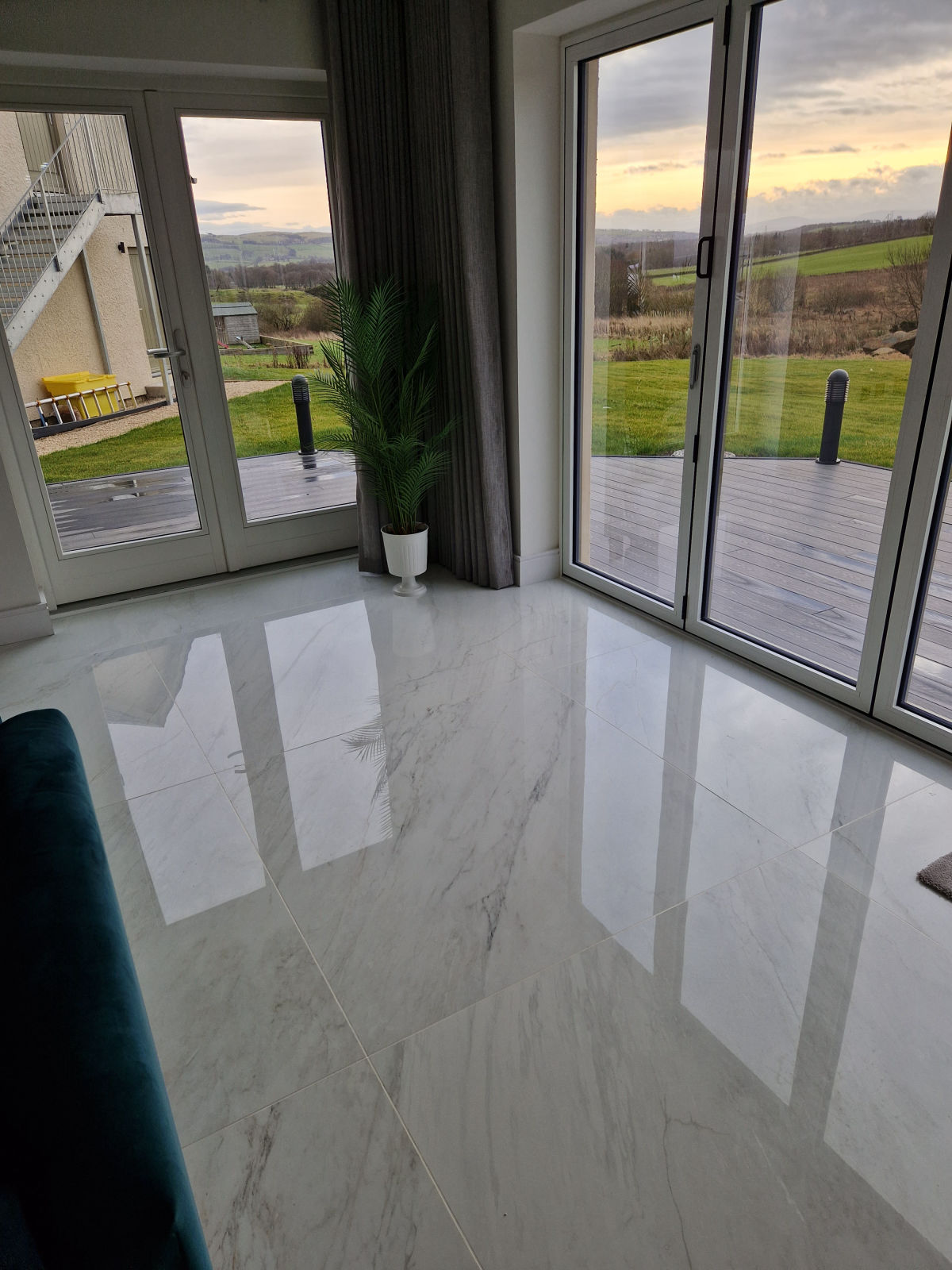 A polished marble-effect floor in a living room with full-height patio doors